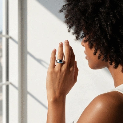 Person wearing a sleek, modern smart ring on their finger with a subtle glow, indicating sleep tracking, on a minimalist background